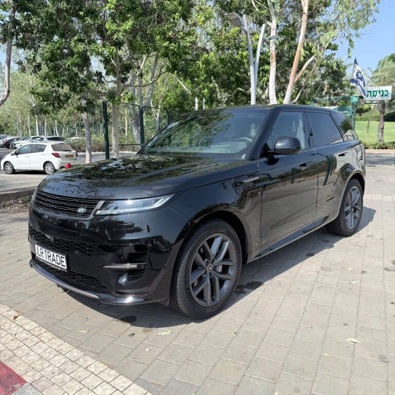 רכב שטח מסוג ריינג' רובר שחור חונה על משטח סלול ליד עצים וצמחייה ביום שטוף שמש. ברקע נראית שלט עם כיתוב בעברית המציין מגבלת מהירות של 30.